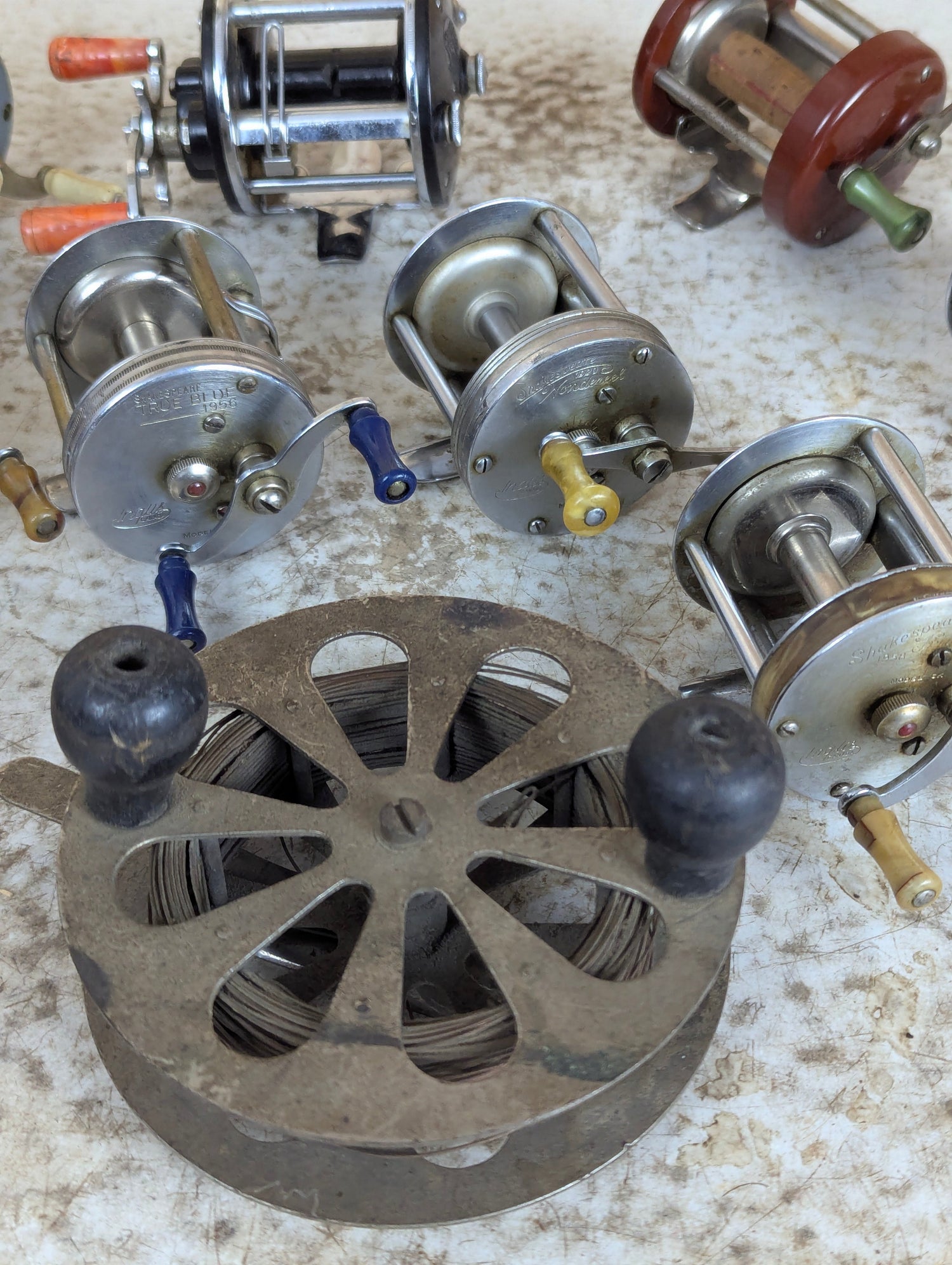 Antique and vintage fishing tackle collection with old reels, lures, rods and tackle box storage