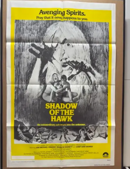 Movie poster for 'Shadow of the Hawk' with a yellow border on a shelf.